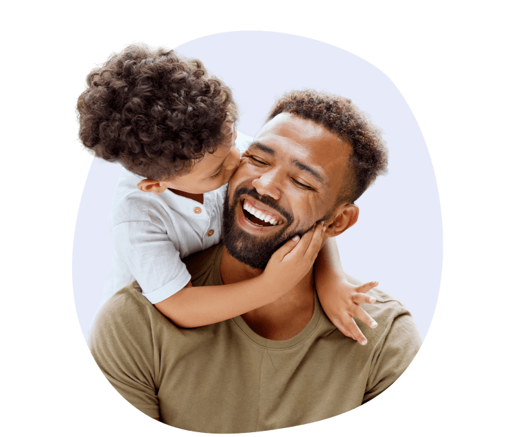 Smiling woman giving a piggyback ride to a laughing young girl.